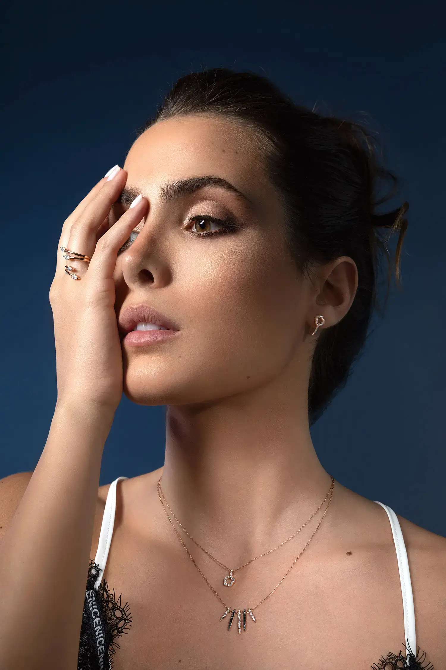 Model wearing Warbonnet black diamond pendant necklace in 18kt rose gold with black and white diamond drops