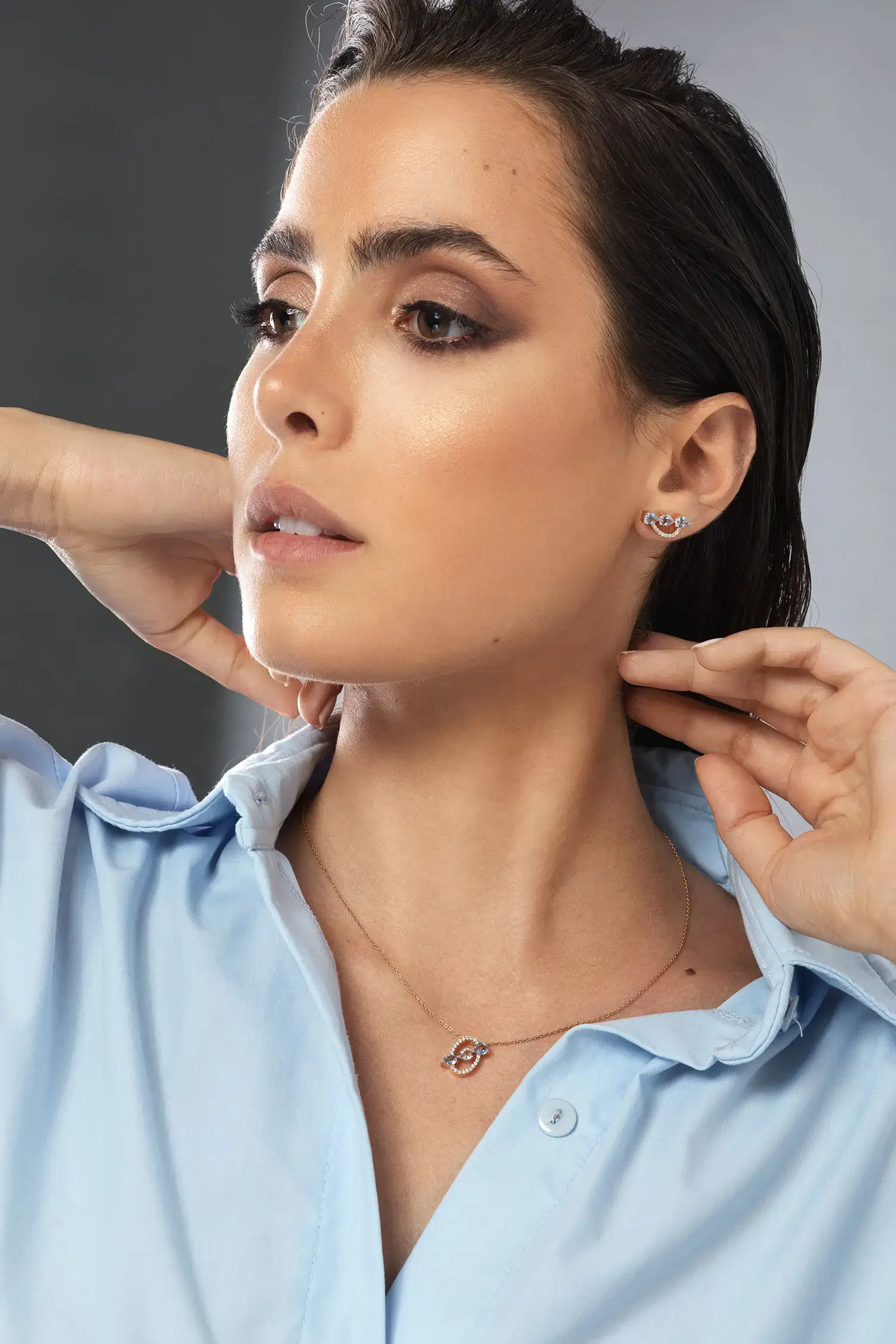 Model wearing Arrow multi color sapphire diamond stud earrings in 18kt rose gold with pear-shaped sapphires and sparkling diamonds
