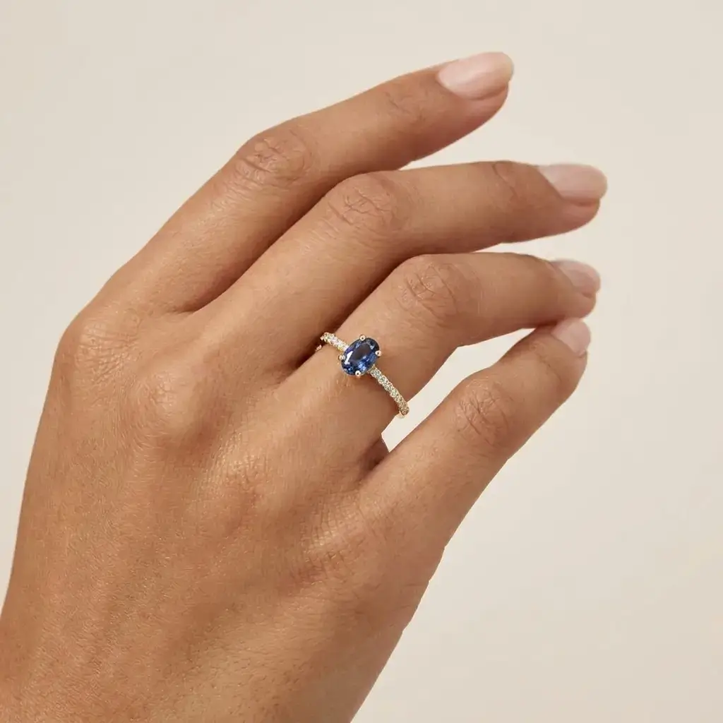 Blue Grace Ring in yellow gold with an oval blue sapphire and pavé diamond band