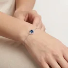 Celeste Bracelet in white gold with a central oval blue sapphire and diamond halo