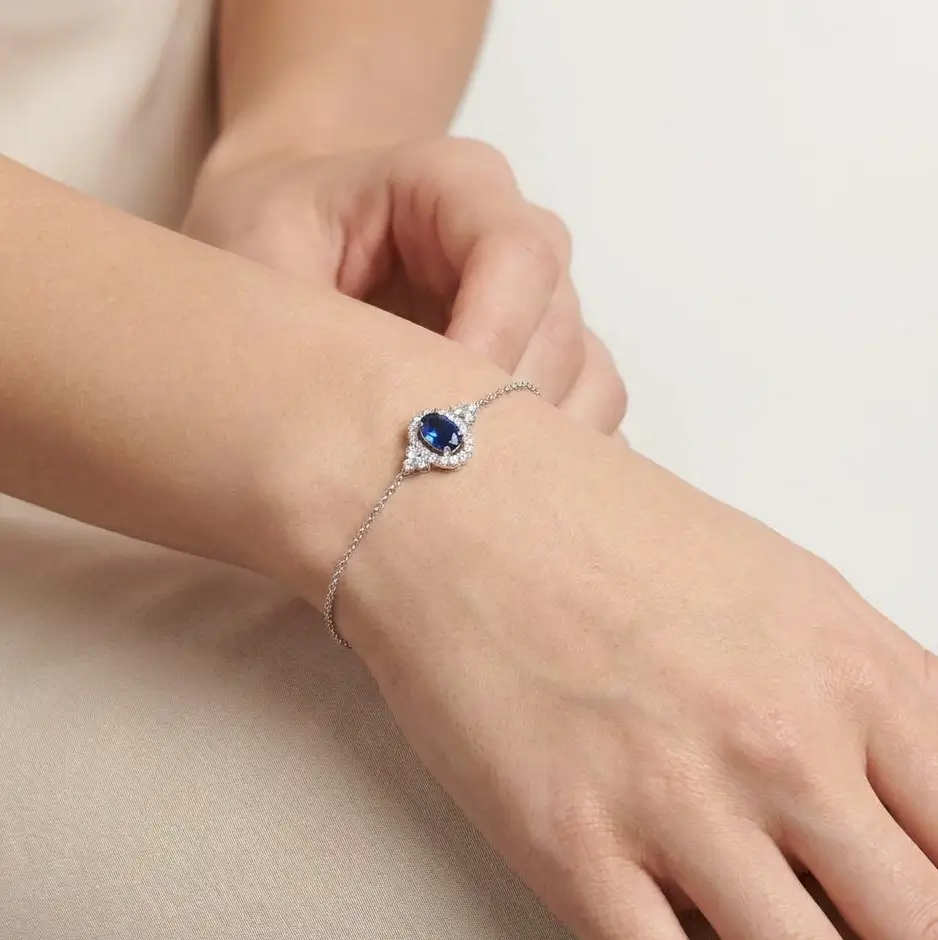 Celeste Bracelet in white gold with a central oval blue sapphire and diamond halo