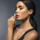 Model wearing Cercle diamond circle drop earrings in 18kt rose gold with delicate chain drops and diamond details