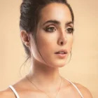 Model wearing Geometric Pendant ruby diamond geometric pendant necklace in 18kt rose gold with a pear-shaped ruby and sparkling diamond design