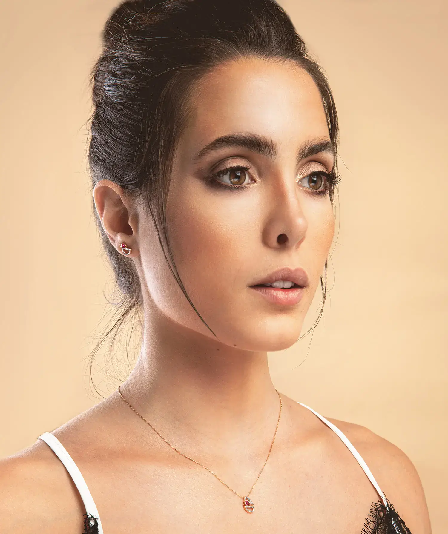Model wearing Geometric Pendant ruby diamond geometric pendant necklace in 18kt rose gold with a pear-shaped ruby and sparkling diamond design
