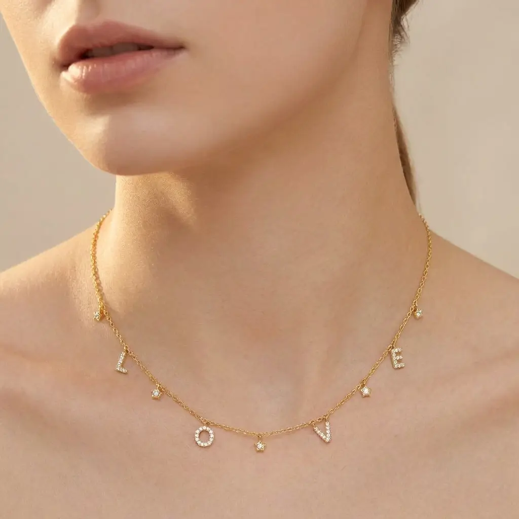 Love Necklace in yellow gold with diamond-set letters and delicate star charms